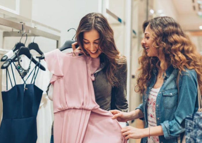 Dos mujeres mirando ropa en un local